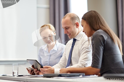 Image of smiling business people with tablet pc in office