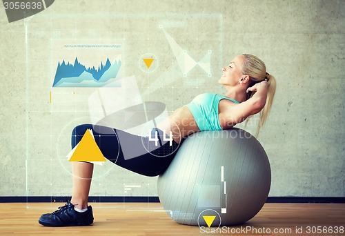 Image of smiling woman with exercise ball in gym