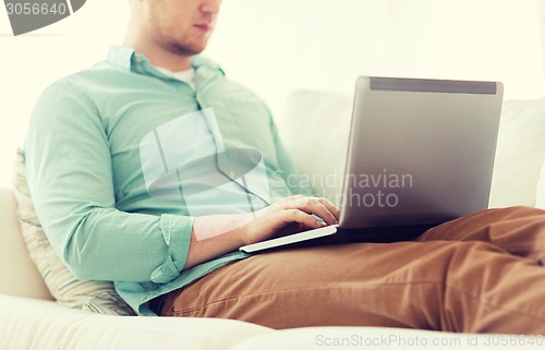 Image of close up of man working with laptop at home