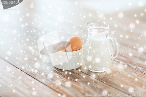 Image of close up of milk jugful and eggs in bowl