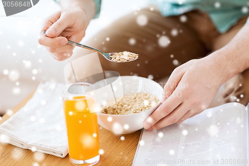 Image of close up of man with magazine eating breakfast