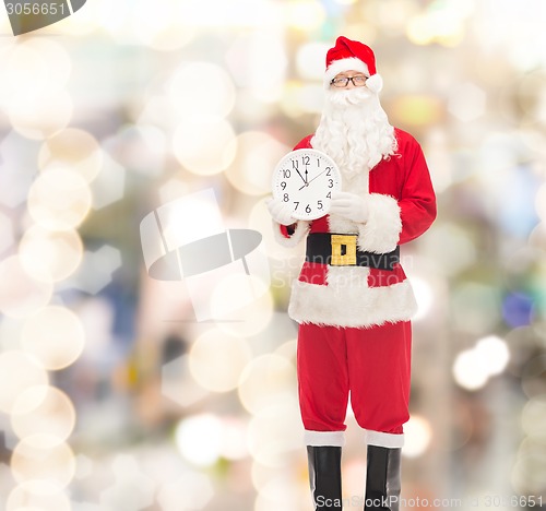 Image of man in costume of santa claus with clock