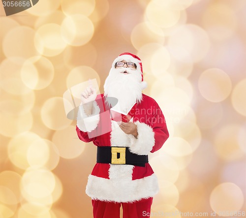 Image of man in costume of santa claus with notepad