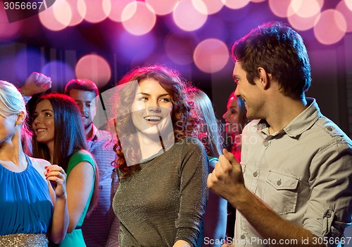 Image of smiling friends dancing in club