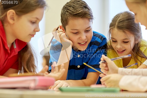 Image of group of students talking and writing at school