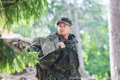 Image of young soldier with backpack in forest