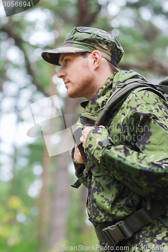 Image of young soldier with backpack in forest