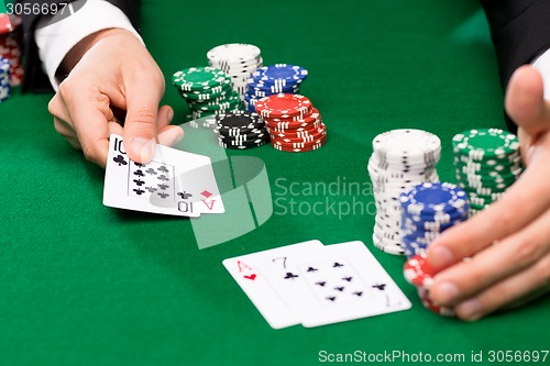 Image of poker player with cards and chips at casino
