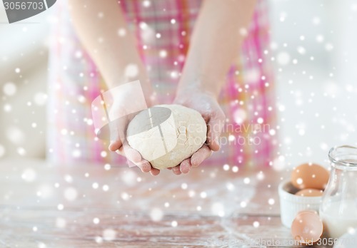 Image of close up of female hands holding bread dough