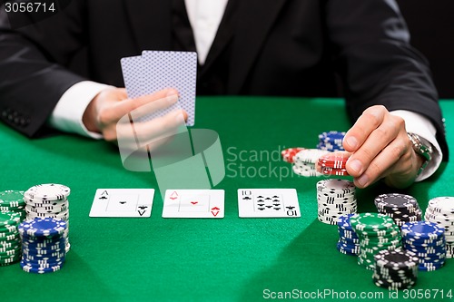 Image of poker player with cards and chips at casino