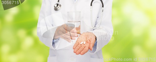 Image of close up of doctor offering pills and water