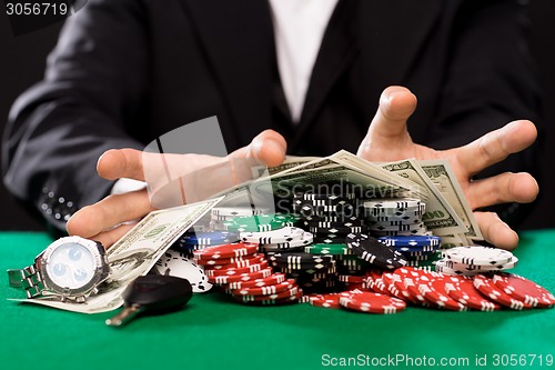 Image of poker player with chips and money at casino table