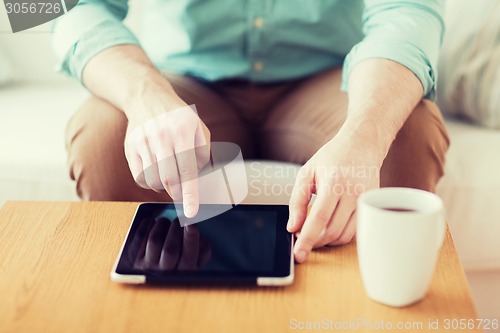 Image of close up of man with laptop and cup at home