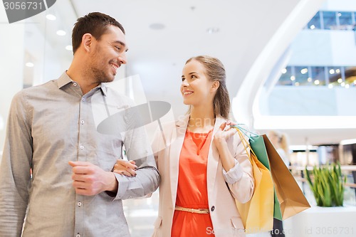 Image of happy young couple with shopping bags in mall