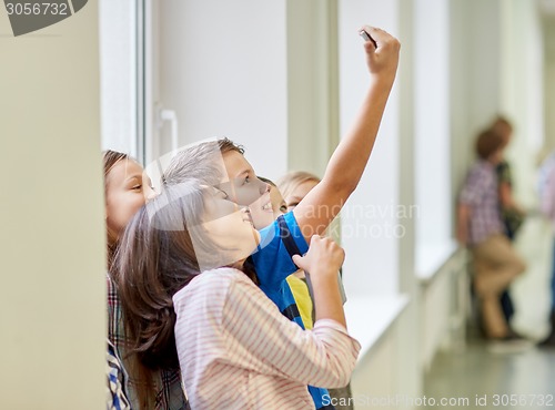 Image of group of school kids taking selfie with smartphone