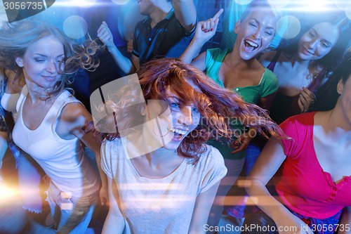 Image of smiling friends dancing in club