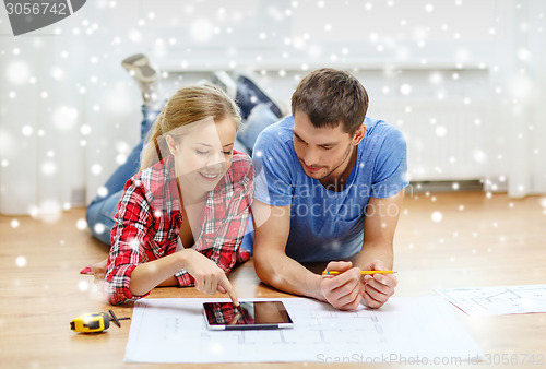 Image of smiling couple with tablet pc at home