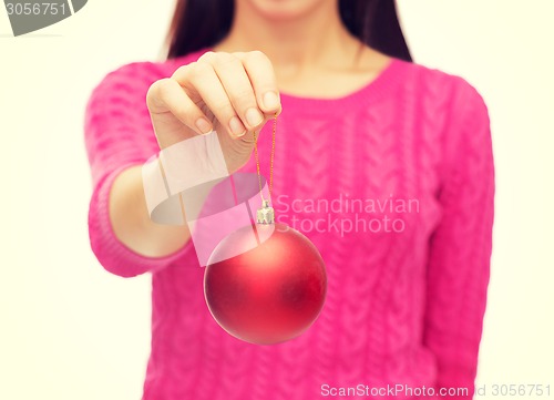 Image of close up of woman in sweater with christmas ball