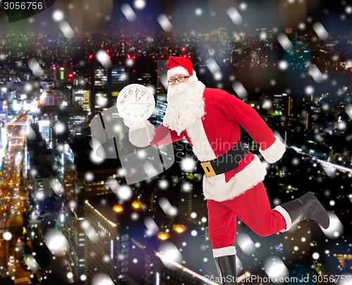 Image of man in costume of santa claus with clock