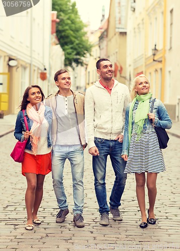 Image of group of smiling friends walking in the city