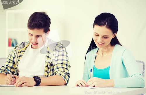 Image of smiling students with textbooks at school