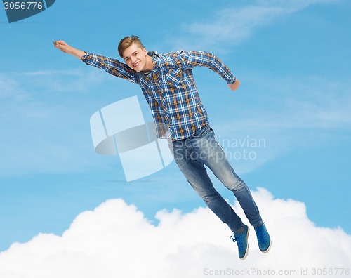 Image of smiling young man jumping in air