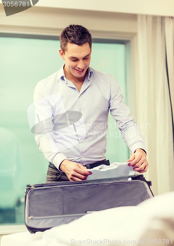 Image of businessman packing things in suitcase