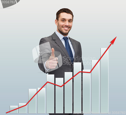 Image of smiling businessman with graph showing thumbs up