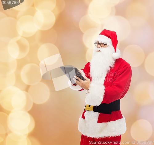 Image of man in costume of santa claus with tablet pc