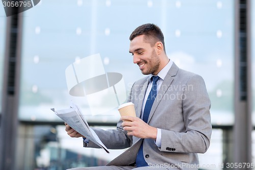 Image of young businessman with coffee and newspaper