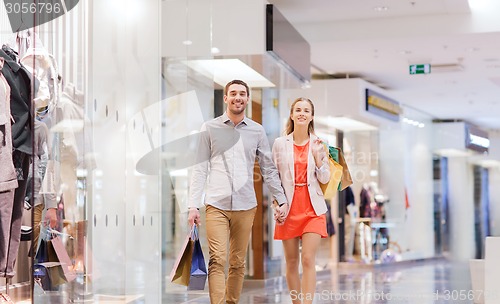 Image of happy young couple with shopping bags in mall