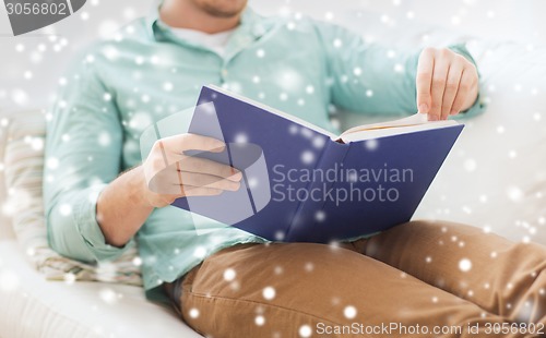 Image of close up of man reading book at home