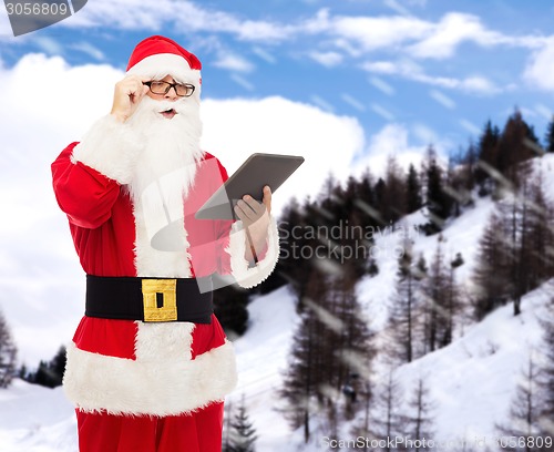 Image of man in costume of santa claus with tablet pc