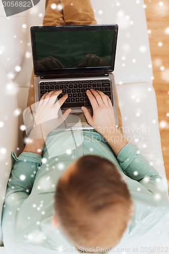 Image of close up of man working with laptop at home