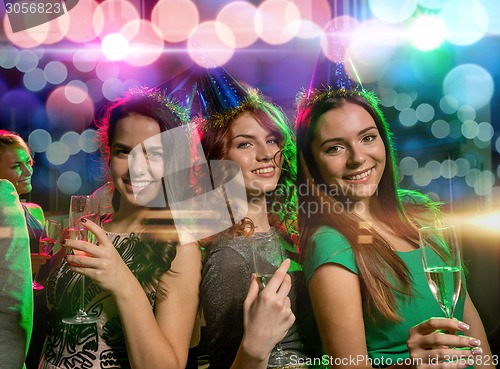 Image of smiling friends with glasses of champagne in club