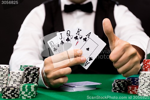 Image of poker player with cards and chips at casino