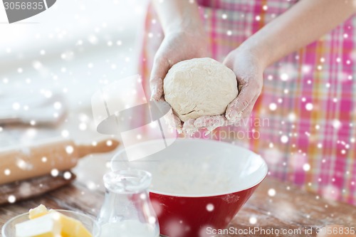 Image of close up of female hands kneading dough at home