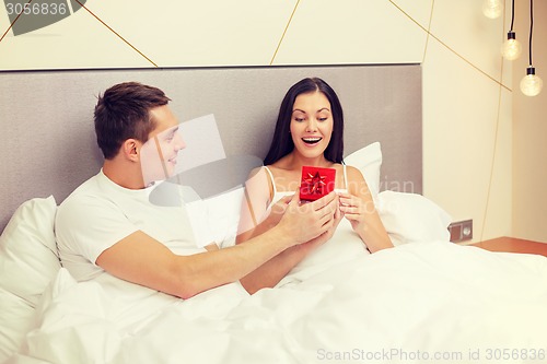 Image of man giving woman little red gift box