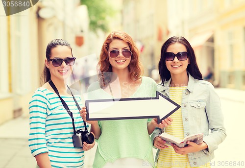 Image of smiling teenage girls with white arrow outdoors