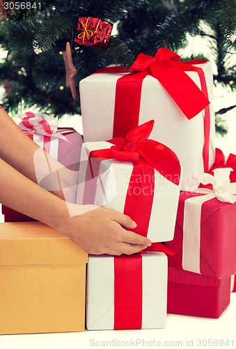 Image of close up of woman with presents and christmas tree