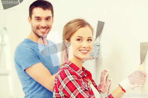 Image of smiling couple doing renovations at home