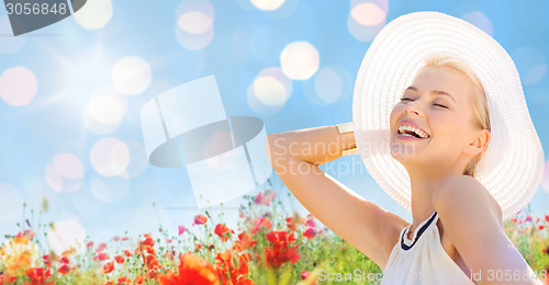 Image of smiling young woman in straw hat on poppy field