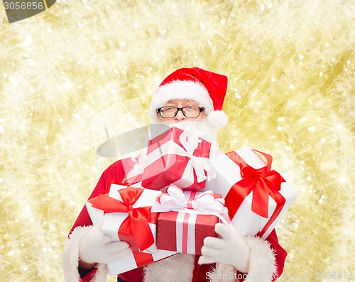 Image of man in costume of santa claus with gift boxes