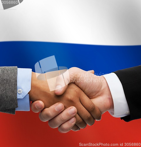 Image of close up of handshake over russian flag