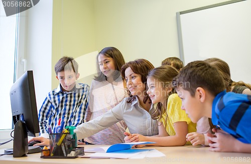 Image of group of kids with teacher and computer at school