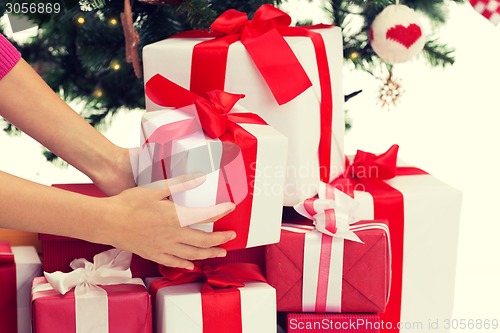 Image of close up of woman with presents and christmas tree