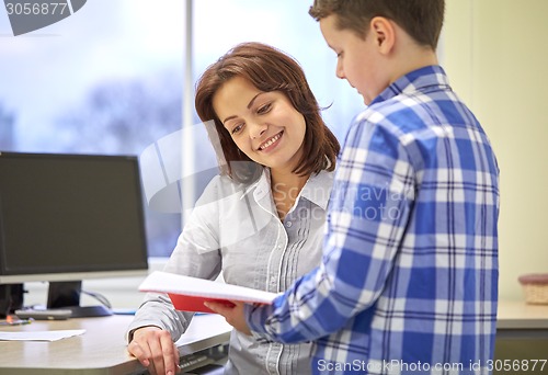 Image of school boy with notebook and teacher in classroom