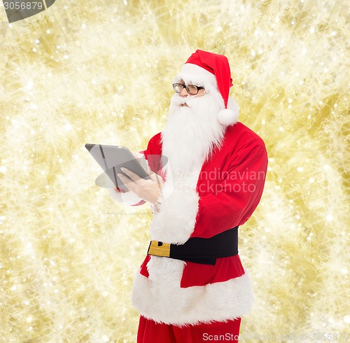 Image of man in costume of santa claus with tablet pc