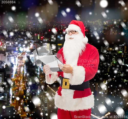 Image of man in costume of santa claus with notepad