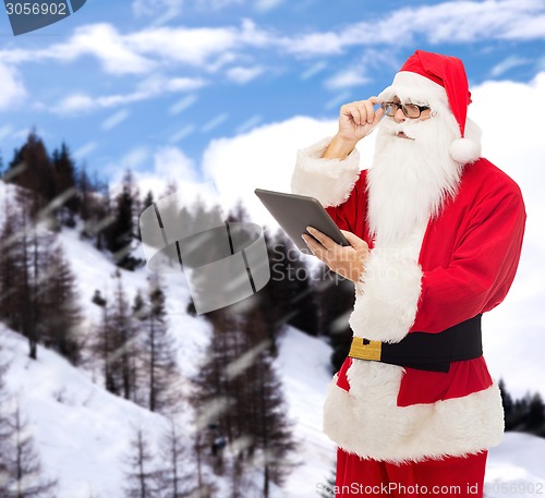 Image of man in costume of santa claus with tablet pc